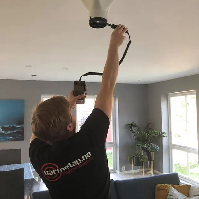 Ansatt jobber med innregulering av nytt ventilasjonsanlegg